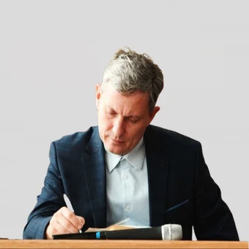 Денис Самарин за столом с книгой
