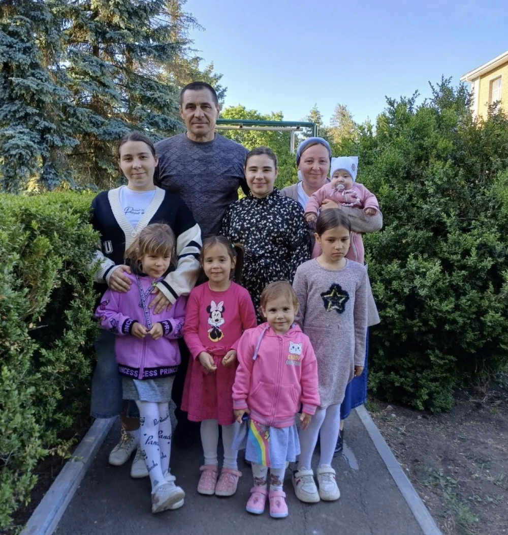 Большая семья с детьми на прогулке среди деревьев